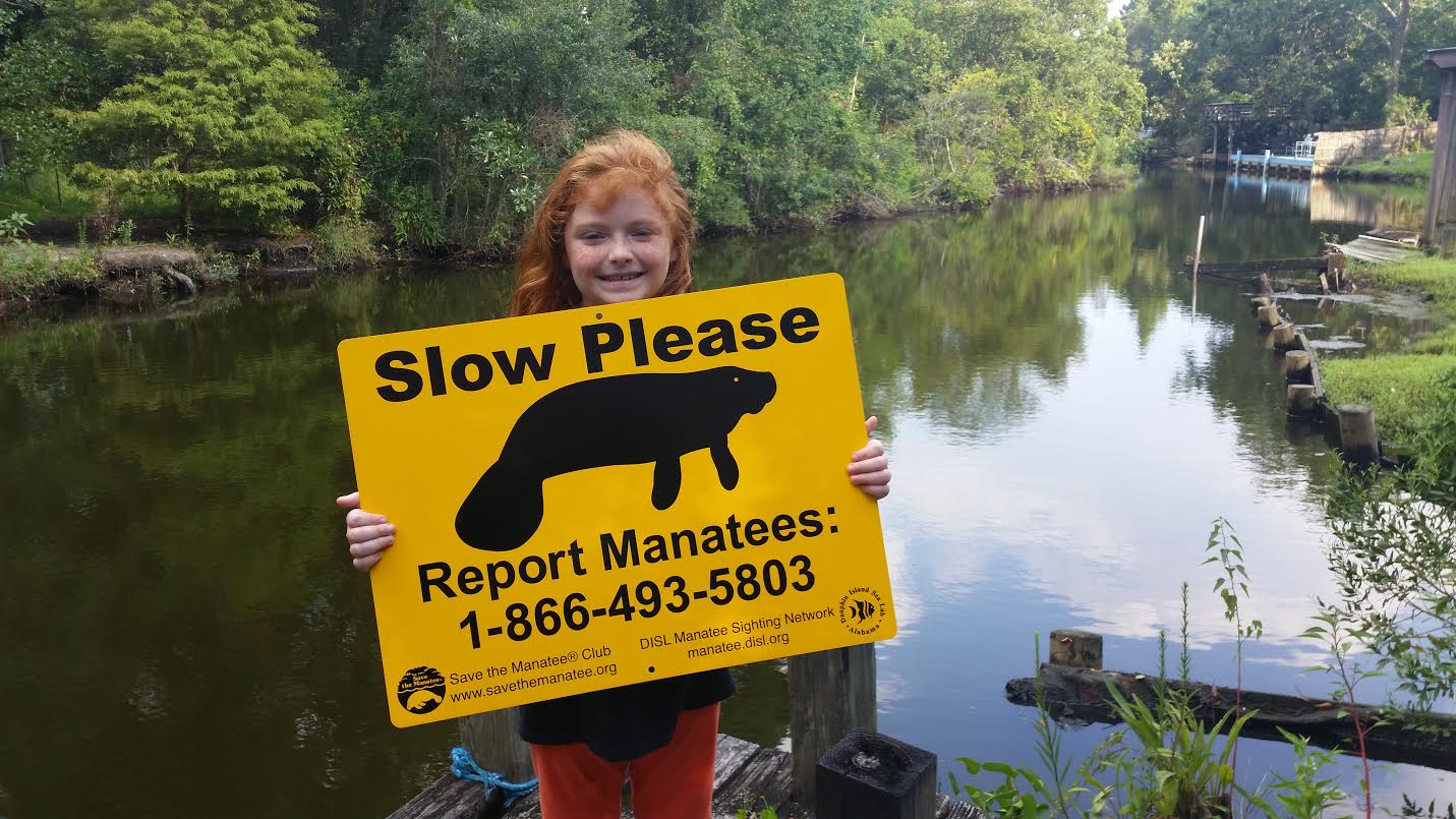 MSN supporter Bella promoting manatee awareness with an MSN dock sign! Credit: DISL/MSN Contributor